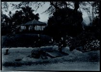 Two priests and a man near thatched shelter, Moanalua Gardens, Oahu.